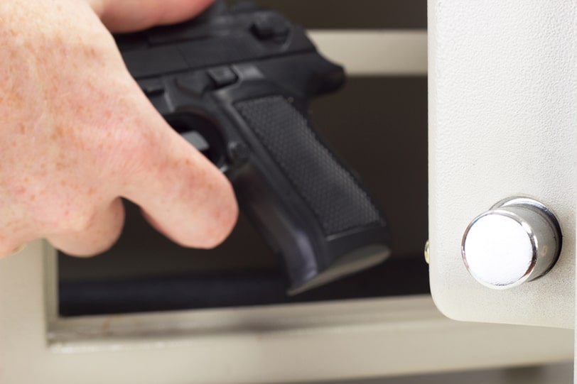 Pistol being placed into safe