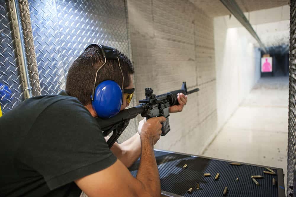 Man shooting rifle at indoor range