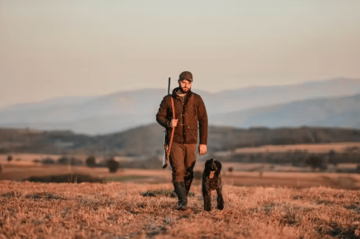 a man standing on a dry grass field