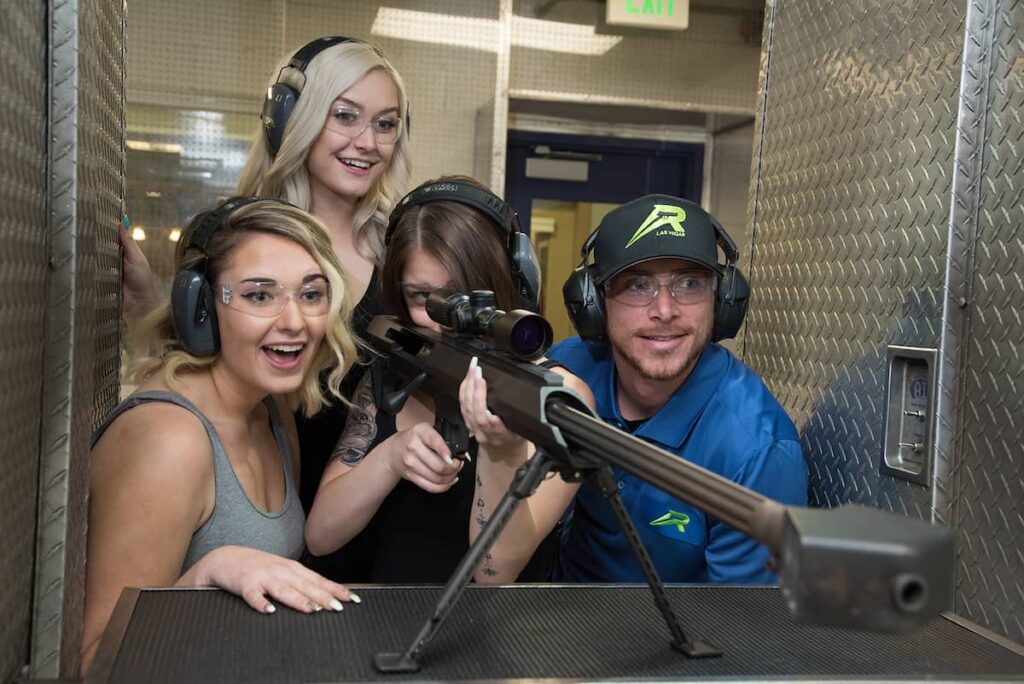 An instructor teaching 3 women on shooting a gun.