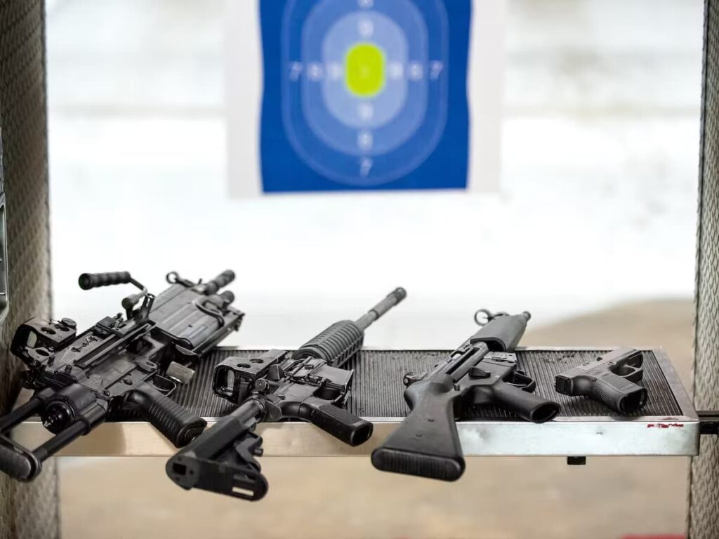 variety of guns laying on a shooting stand at a shooting range in las vegas