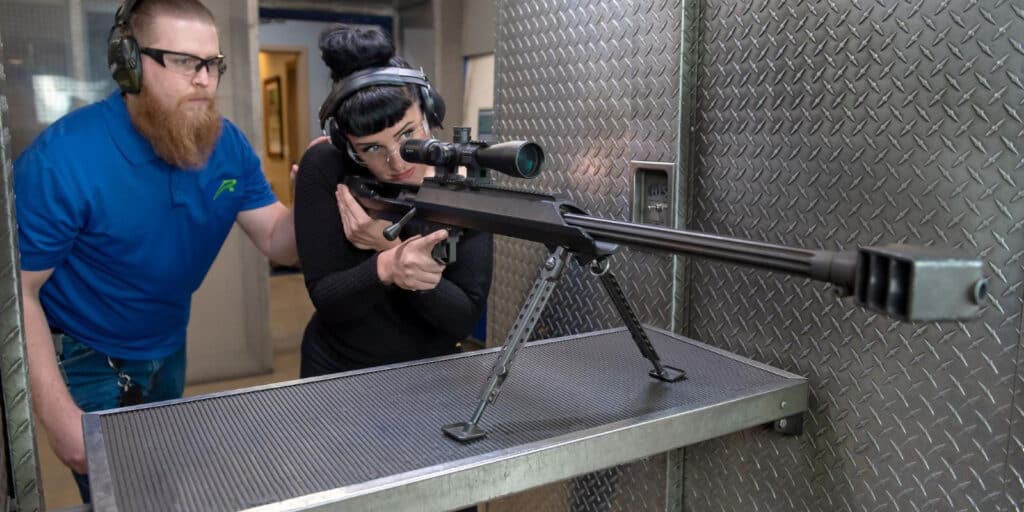 woman with trainer firing a 50 cal gun