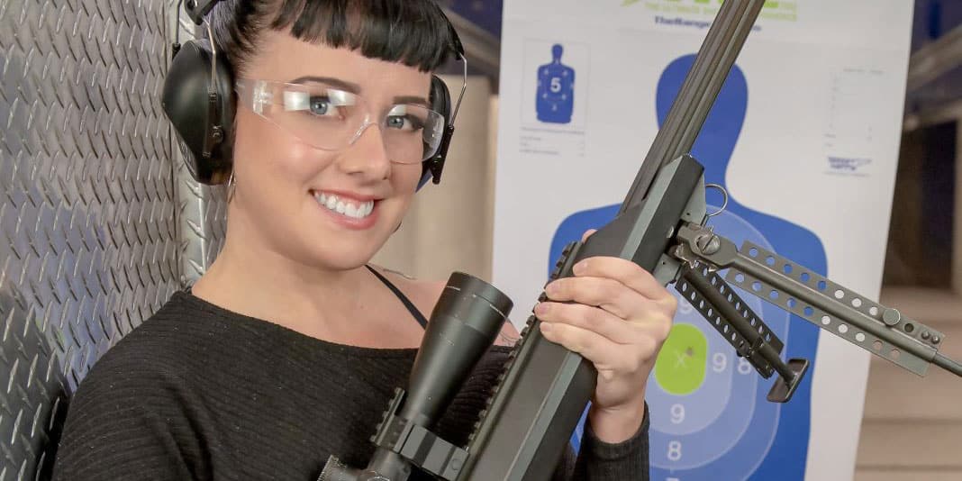 a woman holding a 50 cal gun