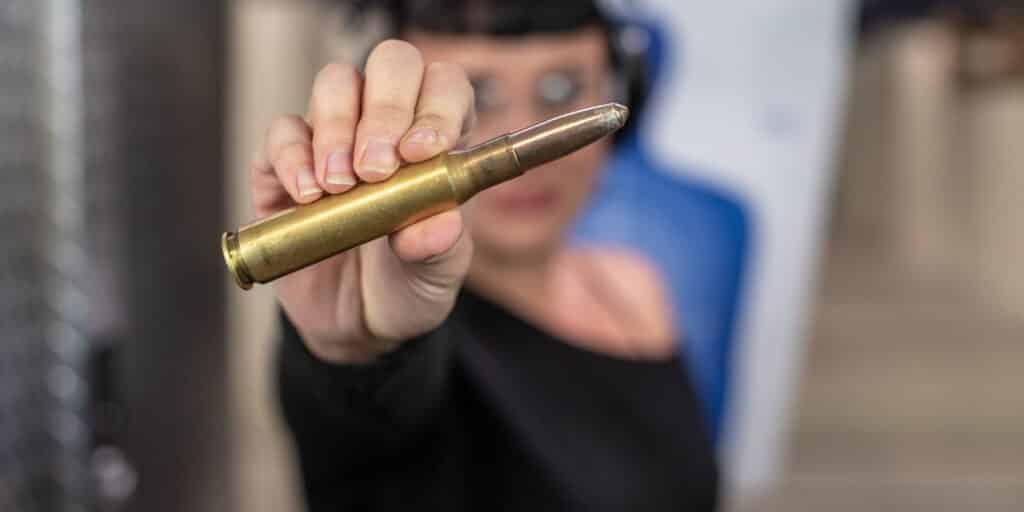 woman holding a 50 cal round