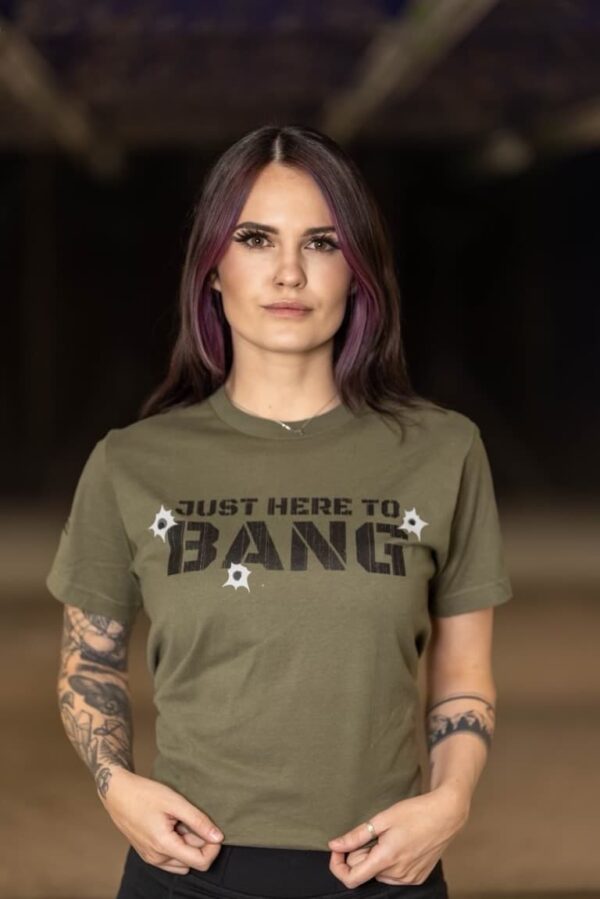 A woman wearing a The Range 702 t-shirt that says "Just here to bang."