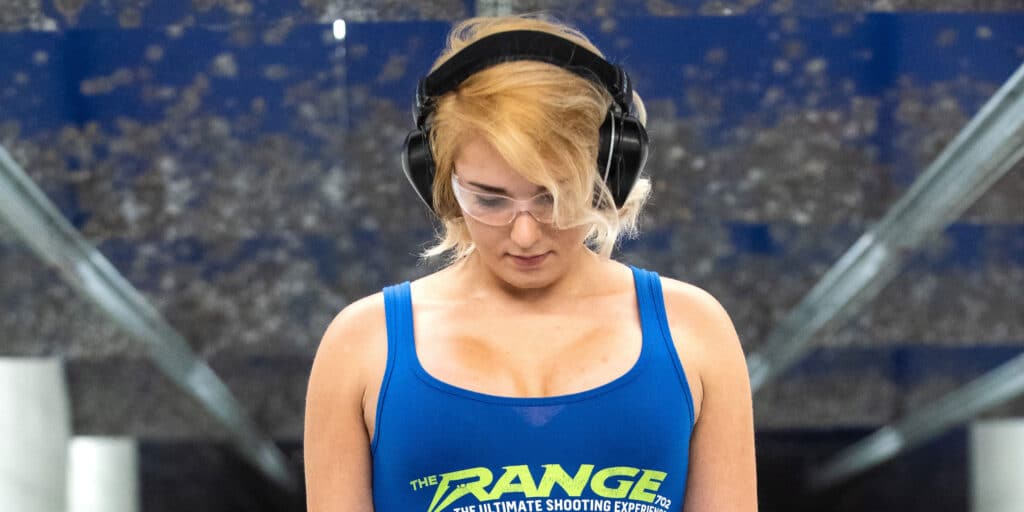 woman looking down wearing shirt of the range 702