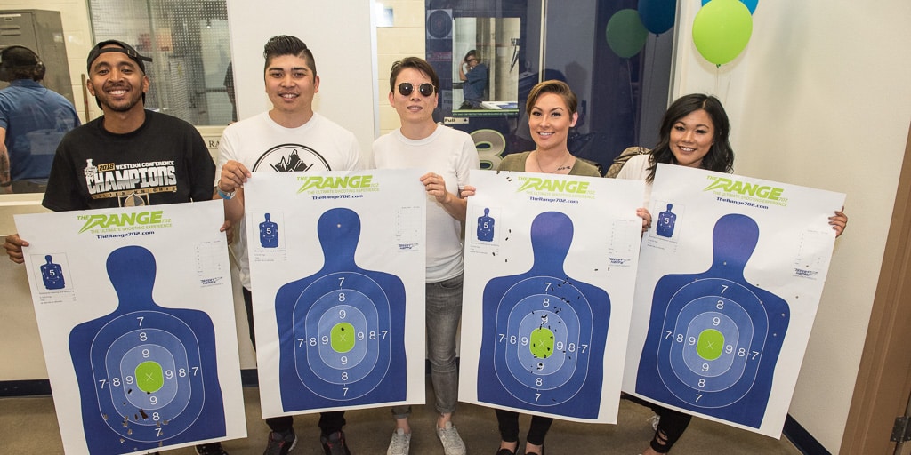 a group of people holding shooting range targets