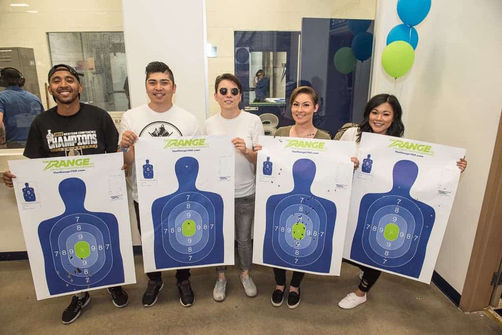 a group of people holding shooting range targets