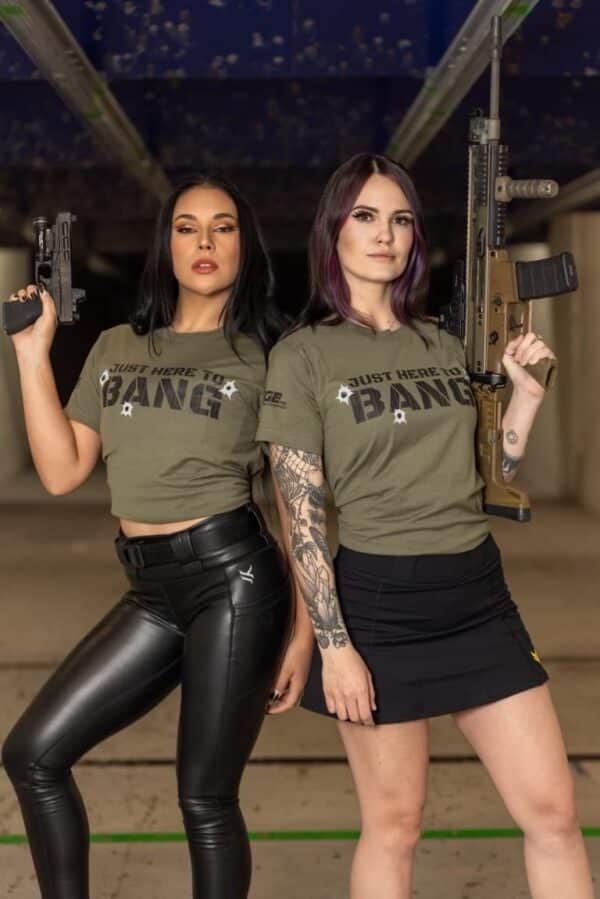 Two women wearing The Range 702 t-shirts that say "Just here to bang."