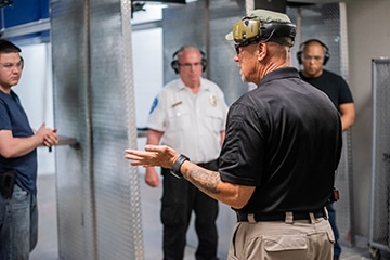 shooting instructor teaching an armed guard class at the range 702