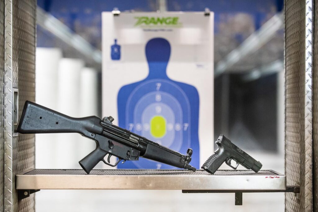 Two guns poised in front of a target at The Range 702.