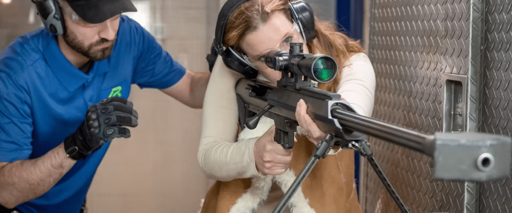 An instructor teaches a woman how to shoot.
