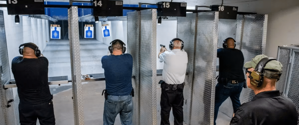 Four men shooting with their instructor standing behind them.