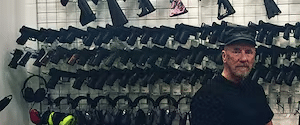 The range 702 instructor standing in front of a wall of guns at a shooting range in las vegas