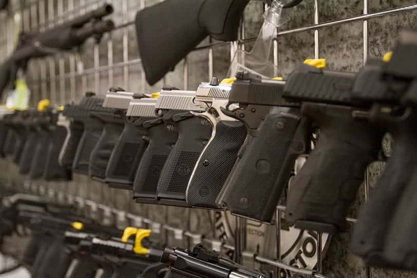 pistols lined up in a holder on a wall