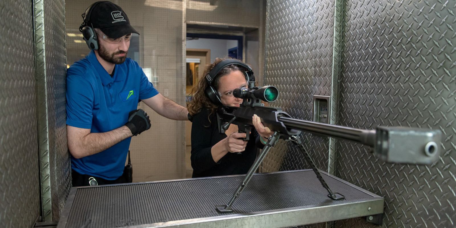 person with gun trainer firing a 50 cal gun