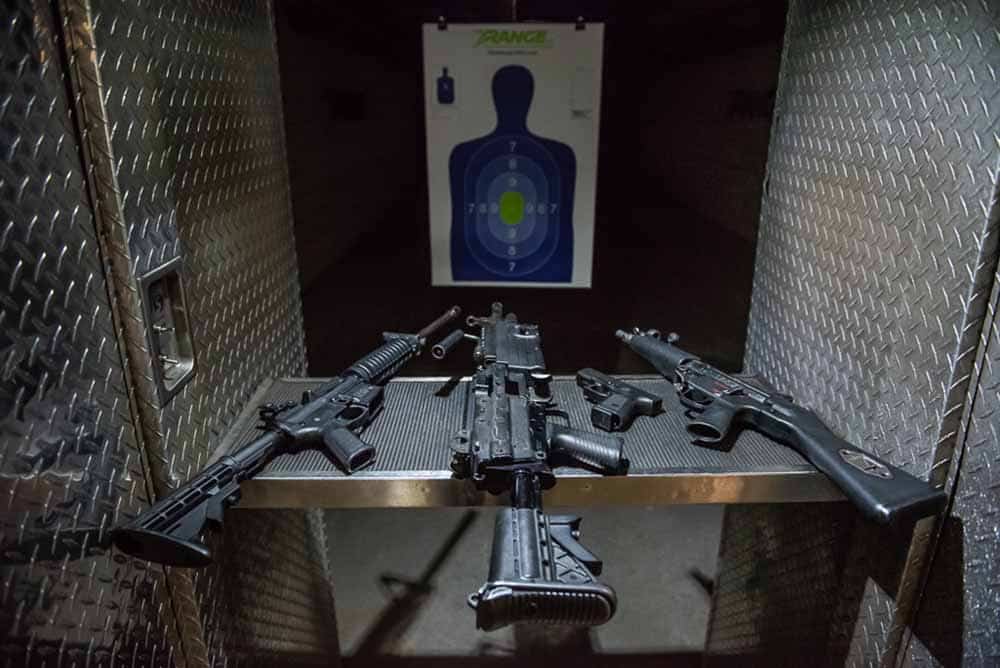 variety of guns on a gun stand at a gun range in las vegas