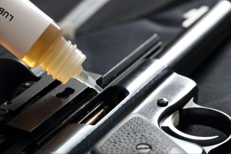 closeup of gun oil lubricating a pistol