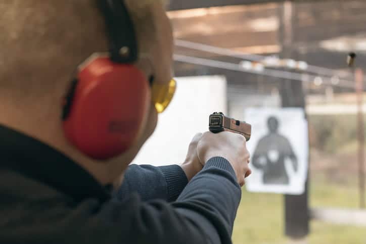 Man aiming a pistol in a shooting range.