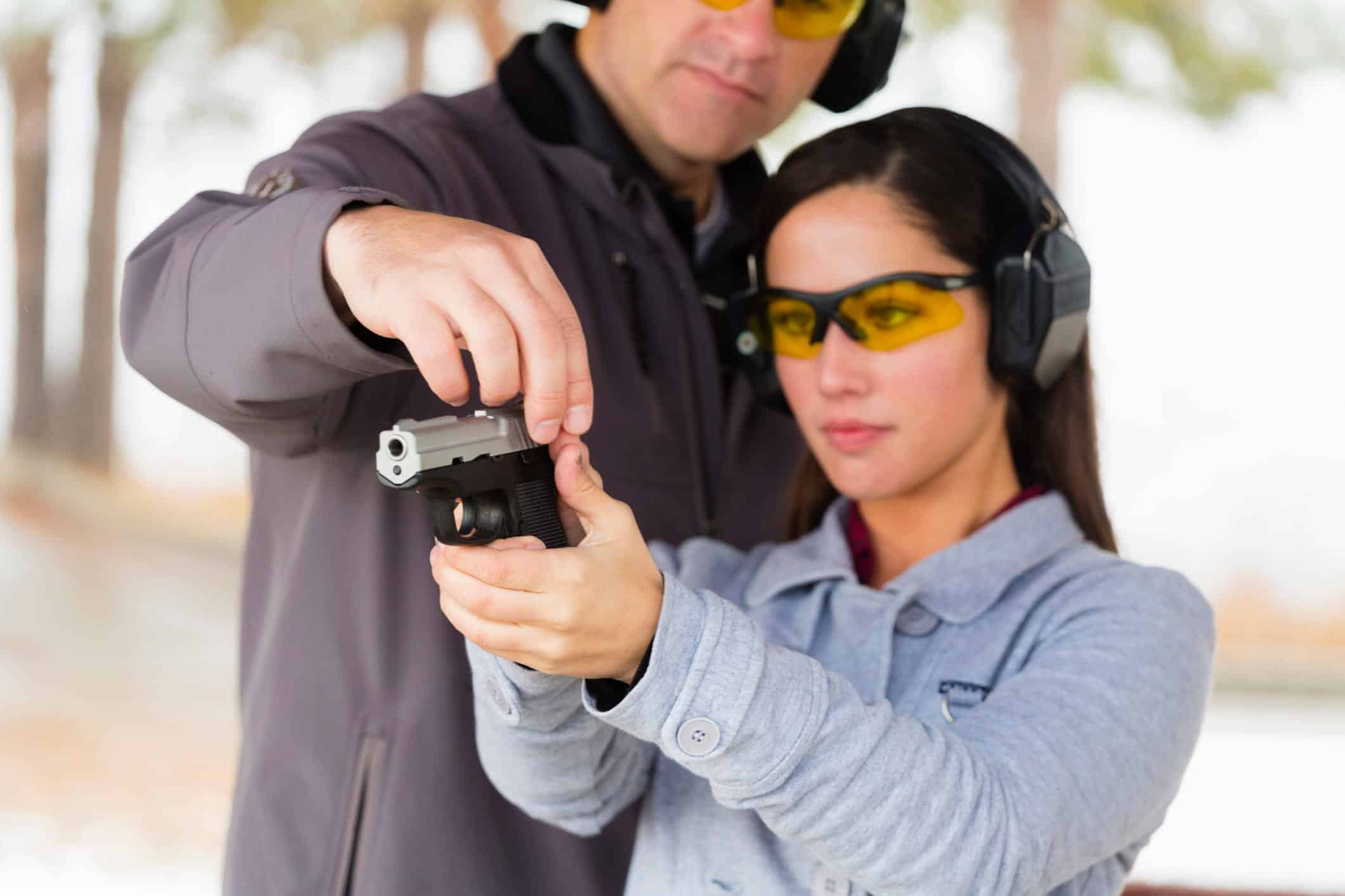 man training woman shooting a pistol